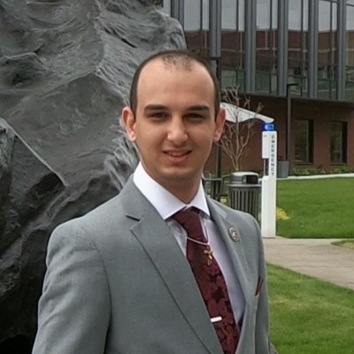 Kevin Manoukian wearing a gray suit outdoors.